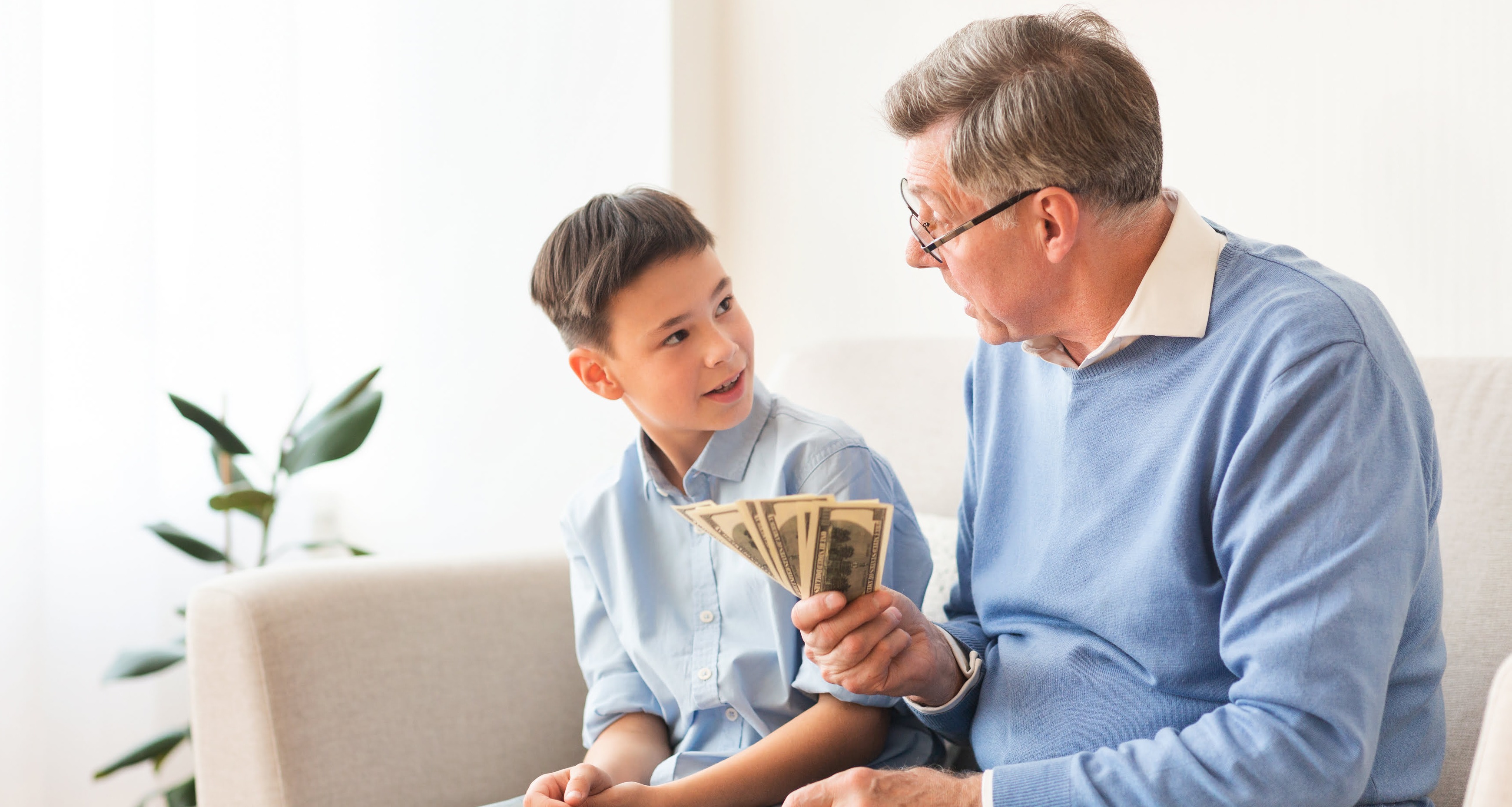 grandfather with grandson showing cash