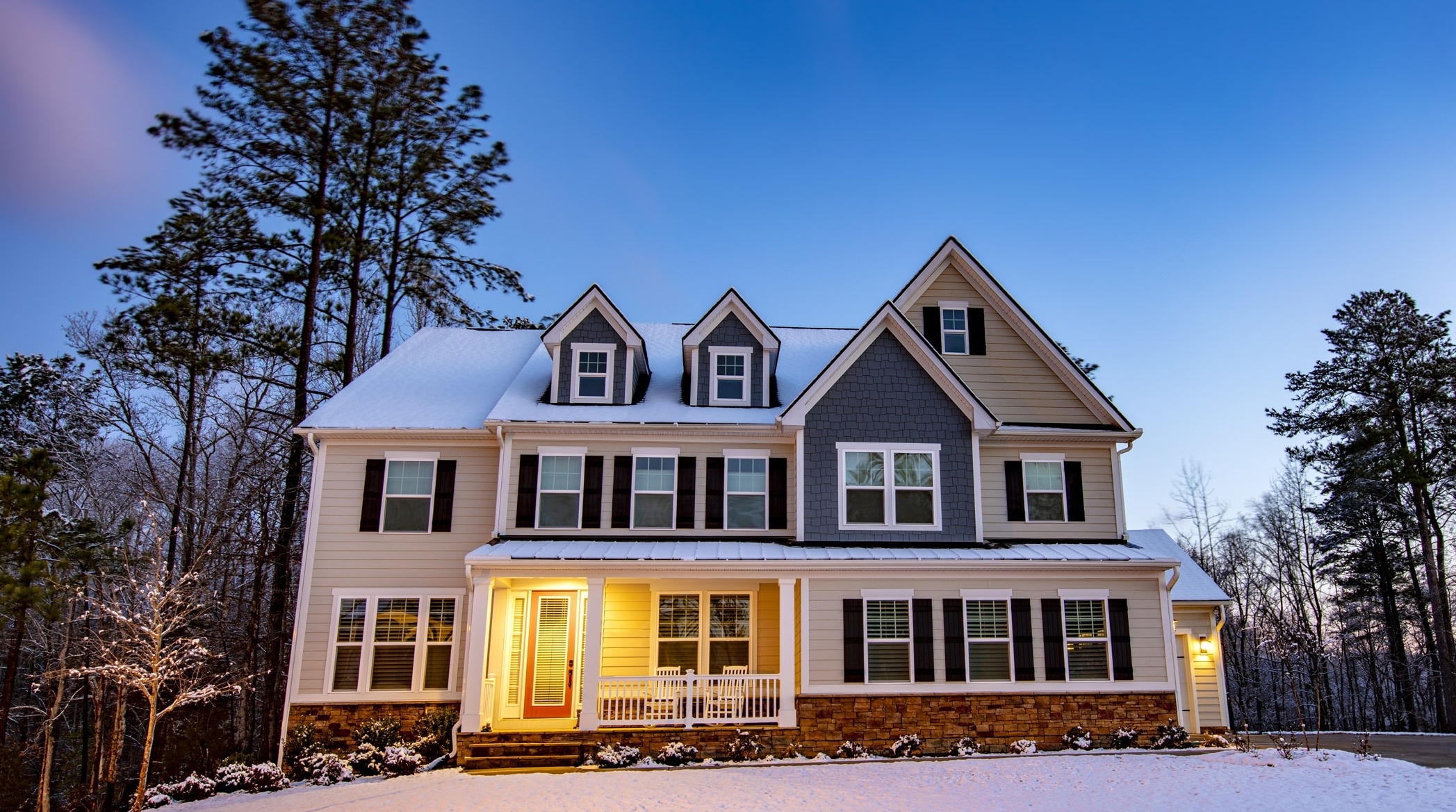 snowy yard with 3 story home