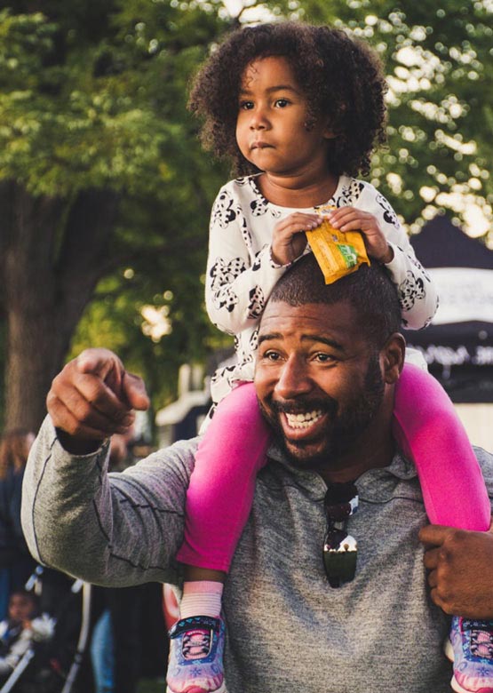 A father and daughter going on a walk in their community