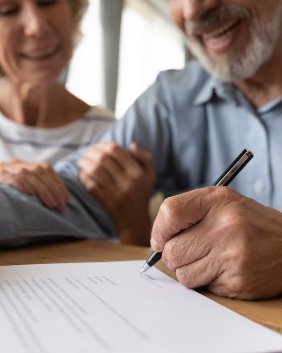 mature man and woman signing papers