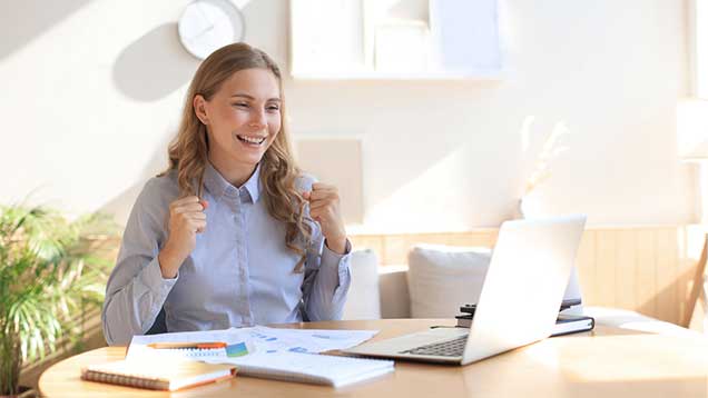 happy young woman sitting at laptop